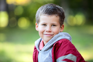 Horizontal portrait of six year old boy in a red jacket