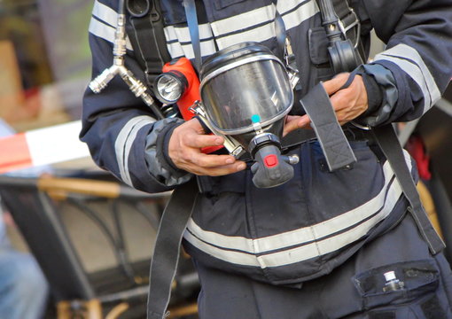 Firefighter holding oxygen or gas mask