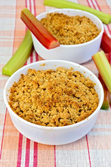 Crumble with rhubarb in two bowls on linen tablecloth