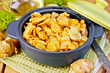 Jerusalem artichokes roasted in pan on board