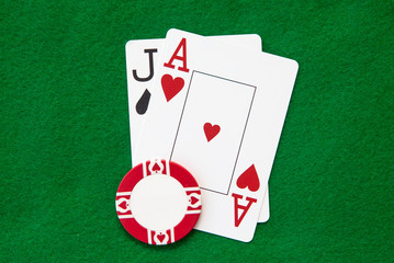 Blackjack hand with casino chip on green casino table