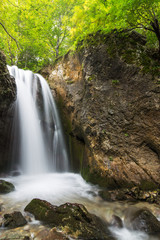 Fototapeta na wymiar Deep forest waterfalls in the Transylvanian Alps