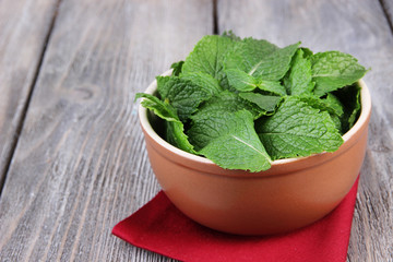 Brown round bowl of fresh mint leaves