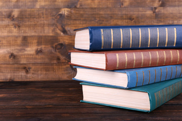 Books on wooden table on wooden wall background