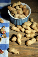Peanuts on blue napkin, on wooden background