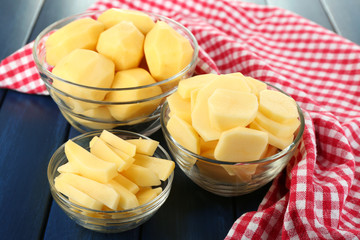 Raw peeled and sliced potatoes in glass bowls