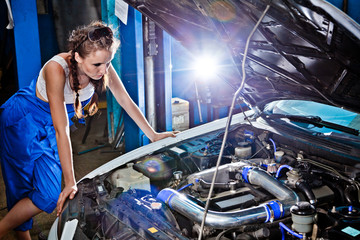 Female auto mechanic repairing a car