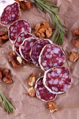 French salami and walnuts on craft paper background