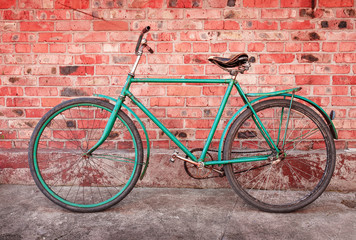 Fototapeta na wymiar Old retro bicycle against brick wall