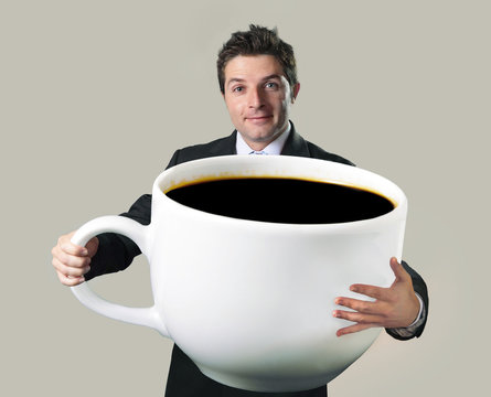 businessman holding oversized cup of black cof