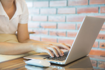 Fototapeta premium Closeup of business woman hand typing on laptop keyboard with mo