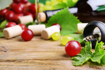 Wine bottle corks with grapes on table close-up