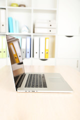 Laptop on wooden table on folders background