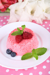 Round shaped cake with berries on plate on polka dot table