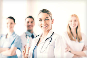 Fototapeta premium female doctor holding syringe with injection