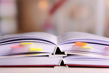 Books with bookmarks on table on bright background