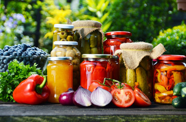 Jars of pickled vegetables in the garden. Marinated food