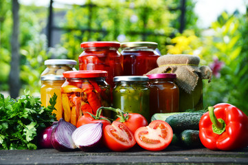 Jars of pickled vegetables in the garden. Marinated food