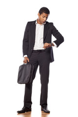 handsome African businessman looking at his wrist watch