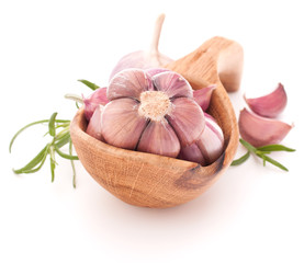 Garlic cloves in wooden bowl isolated on white background