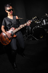 Young woman playing guitar during the concert