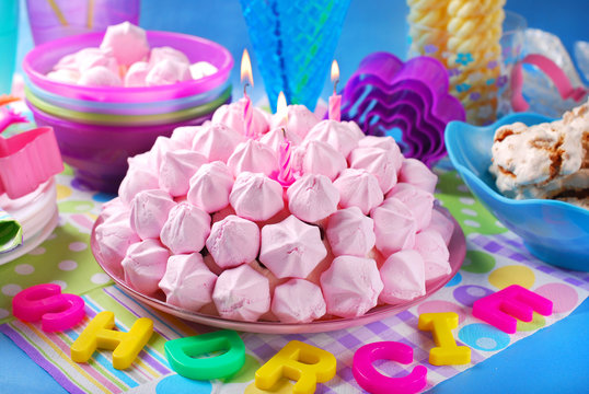 birthday cake with pink meringues and candles