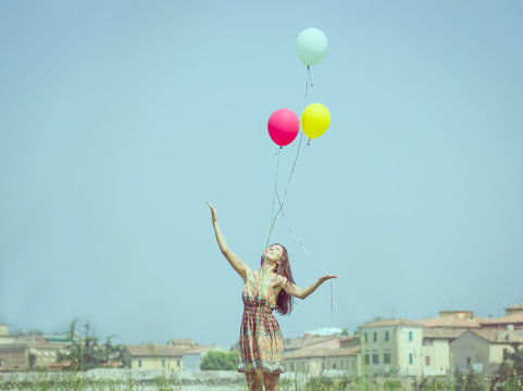 Girl Releasing Balloon In The Sky