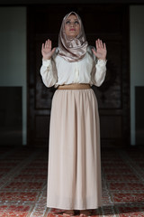 Fototapeta na wymiar Muslim Woman Is Praying In The Mosque