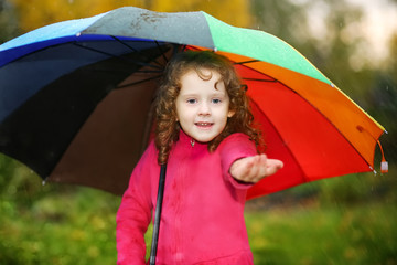 Little girl hiding under an umbrella from the rain.