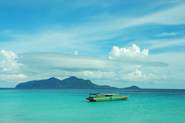 Boat on a sea coast with an island by the background