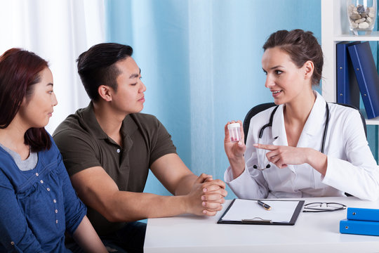 Doctor giving medicines to diverse couple
