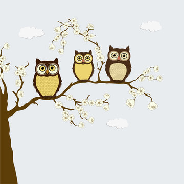 Cute family of owls on a branch with flowers