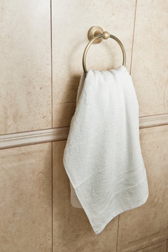 White Hand Towel On Metallic Hanger. Close Up Background