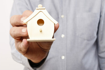 Obraz na płótnie Canvas Man holding tiny wooden house