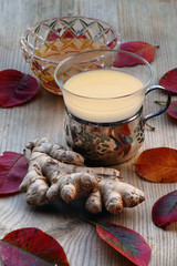 Obraz na płótnie Canvas tea with ginger and honey, silver tea glass, red autumn leaves o