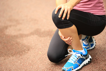  woman runner hold her sports injured knee 