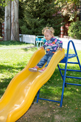 Happy adorable girl on children's slide on playground