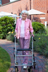 Happy elderly woman using a walking aid.