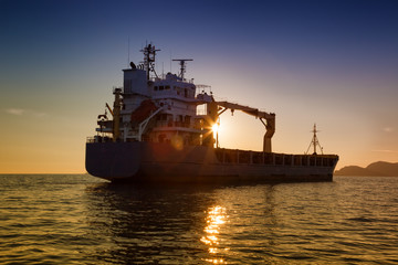 commercial cargo ship at sunset