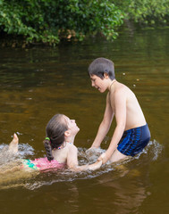 Little boy teaches his little sister to swim