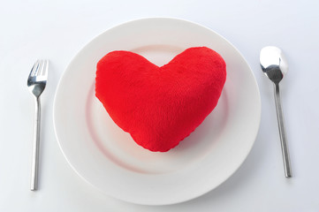 Red heart in plate with fork and spoon