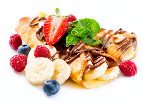 Crepes with banana, chocolate and berries over white
