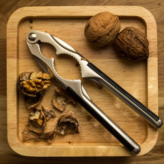 Walnuts and nutcracker on wood table