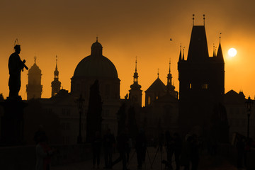Silhouettes of Prague towers and statues on Charles bridge durin