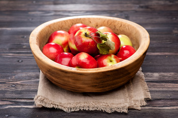 Fototapeta na wymiar Ripe red apples in wooden bowl
