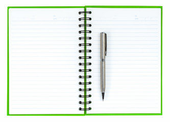 Silver ball point pen on green notebook