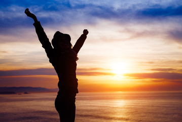 Fototapeta premium Female freedom and happiness on sunset towards the ocean