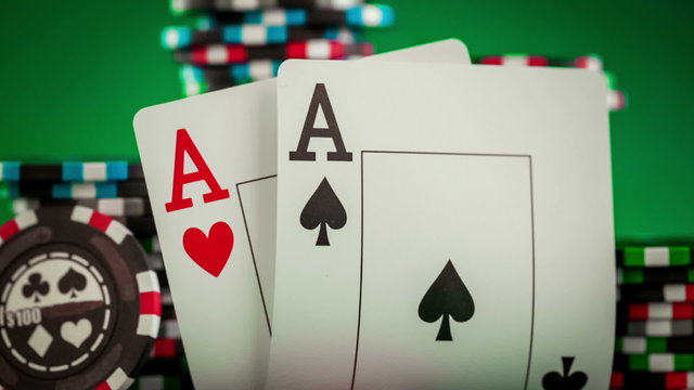 Stack of chips and two aces on the table on the green baize - po