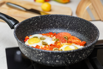 Frying pan with eggs and tomatoes