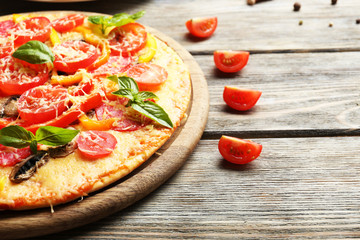 Delicious pizza served on wooden table
